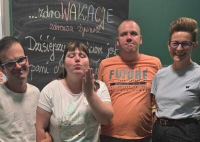 Trzej uczestnicy - dwaj mężczyźni i kobieta - pozują do zdjęcia z zaproszonym gościem, Magdaleną Trzepizur.