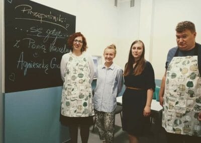 Trzy kobiety i jeden mężczyzna pozują do zdjęcia.