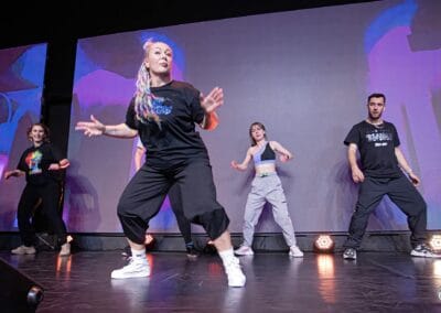 Pięć osób tańczy na scenie podczas wydarzenia "Tanecznym krokiem w niebieski świat autyzmu"