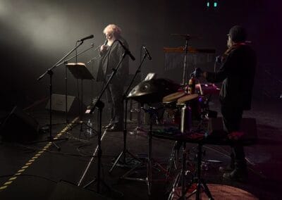 Andrzej Grabowski śpiewa na scenie. Jego postać oświetlona jest reflektorem.