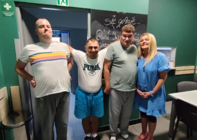 Trzech uczestników Środowiskowego Domu Samopomocy typu D pozuje do zdjęcia z aktorką Iwoną Chołuj.