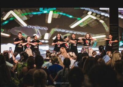 Instruktorzy zumby tańczą na scenie podczas wydarzenia "Tanecznym krokiem w niebieski świat autyzmu"