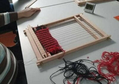 Na zdjęciu widać proces tkania dywaników przy użyciu ramki tkackiej