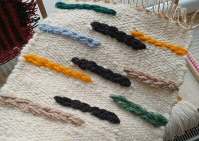 Na zdjęciu widać utkany dywanik z kolorowej wełny