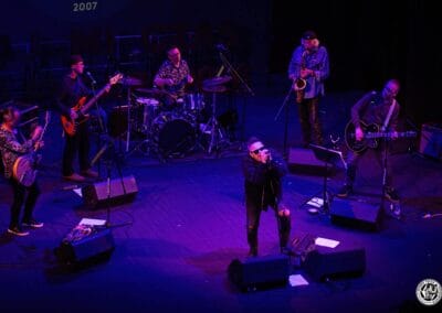 Zdjęcie przedstawia sześciu muzyków na scenie teatralnej.