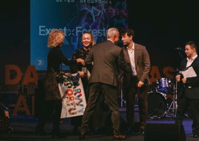 Na zdjęciu przedstawionych jest pięć osób - dwaj prowadzący prezentację kalendarza "Barwy Sportu okiem Skowronka", dwie kobiety oraz mężczyzna. Wszystkie osoby znajdują się na scenie teatralnej.